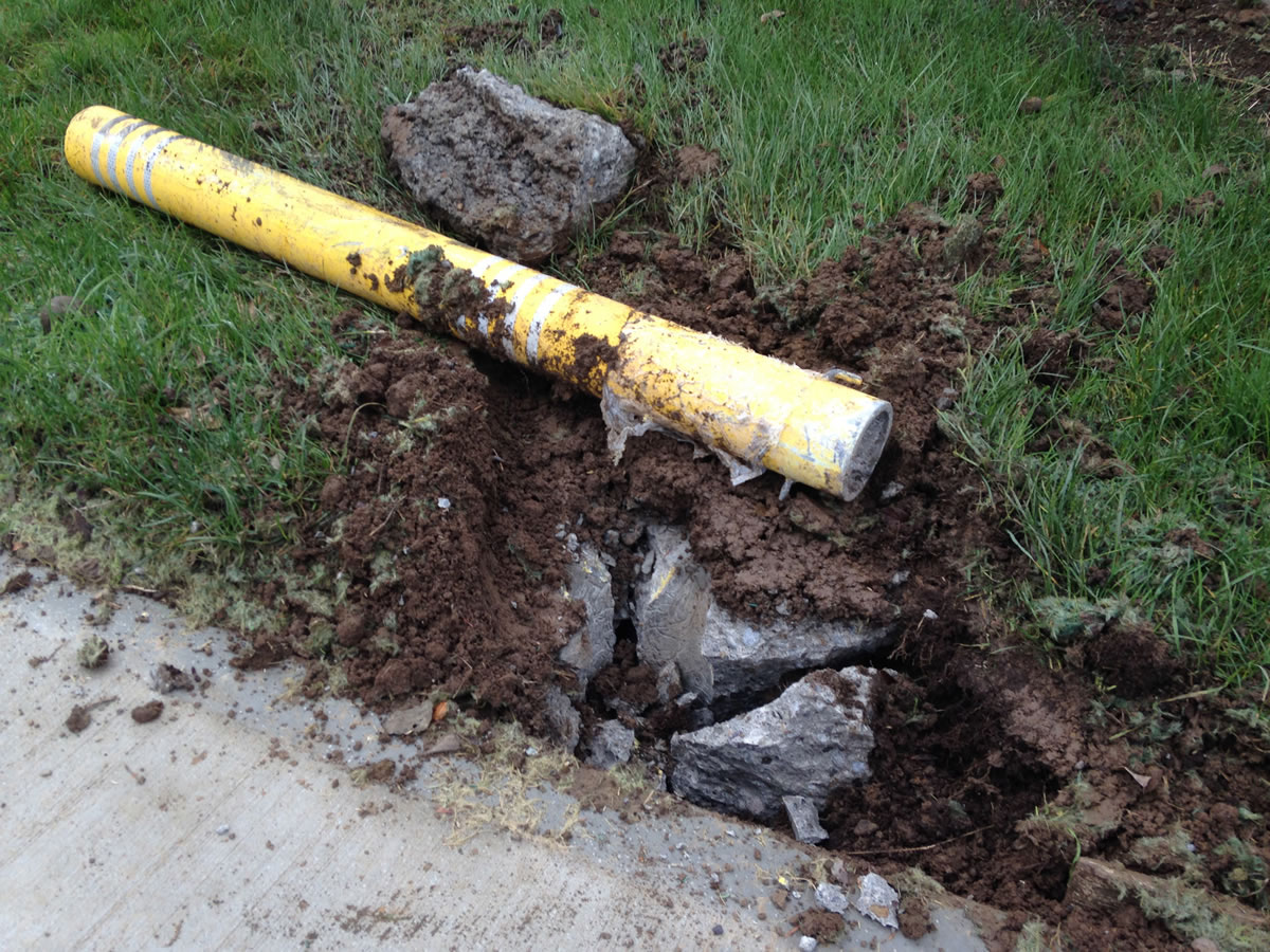 A concrete barrier and metal post were uprooted when a car hopped the curb in front of Jerry Sutherland's home next to the roundabout at N.E.