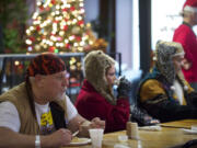 Street minister Coach Hendrix, 58, left, enjoys a hot meal at the annual free Christmas dinner at Chronis' restaurant.