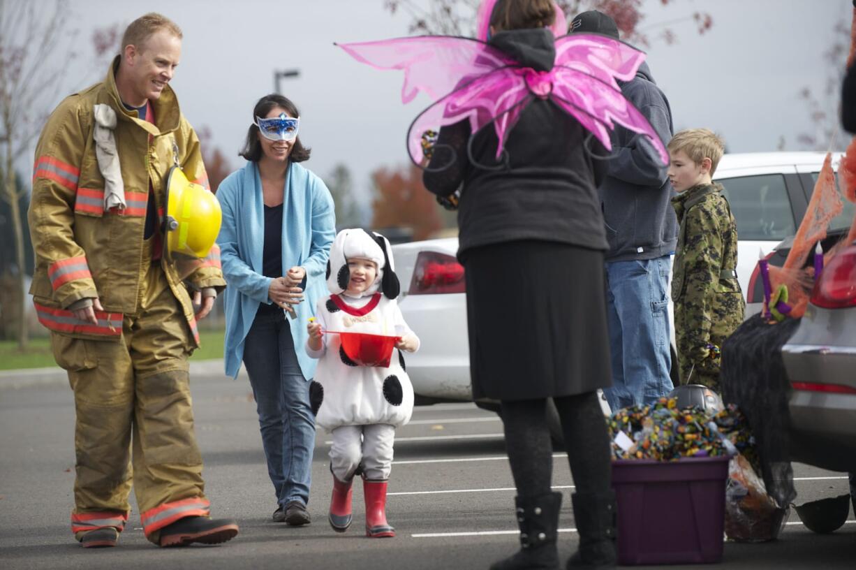 The Rotmans family, from left, Rick, Jenni and Caden, 3, from Vancouver, trick or treat Saturday at the Armed Forces Reserve Center.