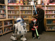 Patty Hastings/The Columbian
Ricky Gartner, 5, looks back at R2-D2 after posing with him, as another creature looks on, at Shahala Middle School's sci-fi family night and book fair.