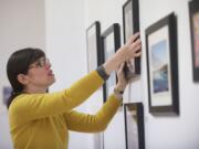 North Bank Artists Gallery member artist and education committee member Rachel Aponte hangs artwork in preparation for the opening of &quot;Clark County and Beyond&quot; art teacher and student art show.