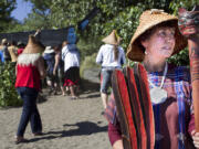 Cowlitz elder Tanna Engdahl presides over the ceremony as three canoes are carried from the Columbia River for an overnight encampment at Fort Vancouver National Historic Site.