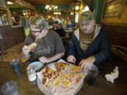 Nathan Burton, left, and his father, Bradley Burton, enjoy lunch at Smokey's Pizza on Monday, the restaurant's final day of business.