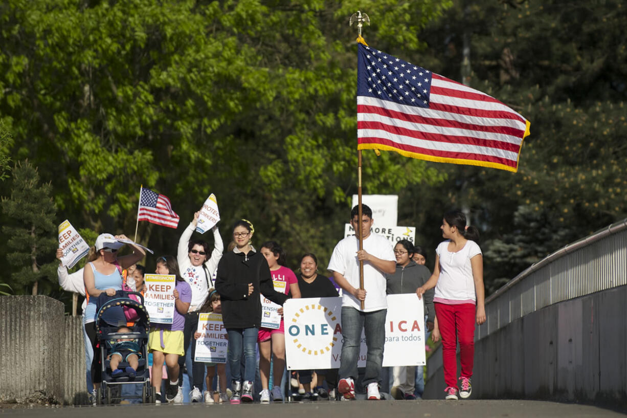 A group of immigration reform supporters marches Wednesday from U.S. Rep. Jaime Herrera Beutler's Vancouver office at the O.O.