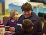 Vancouver resident Leanne White, with her two adopted children Giovanna, 5, and Devlin, 6, listens to speakers at a National Adoption Day event Thursday at the First United Methodist Church in Vancouver.