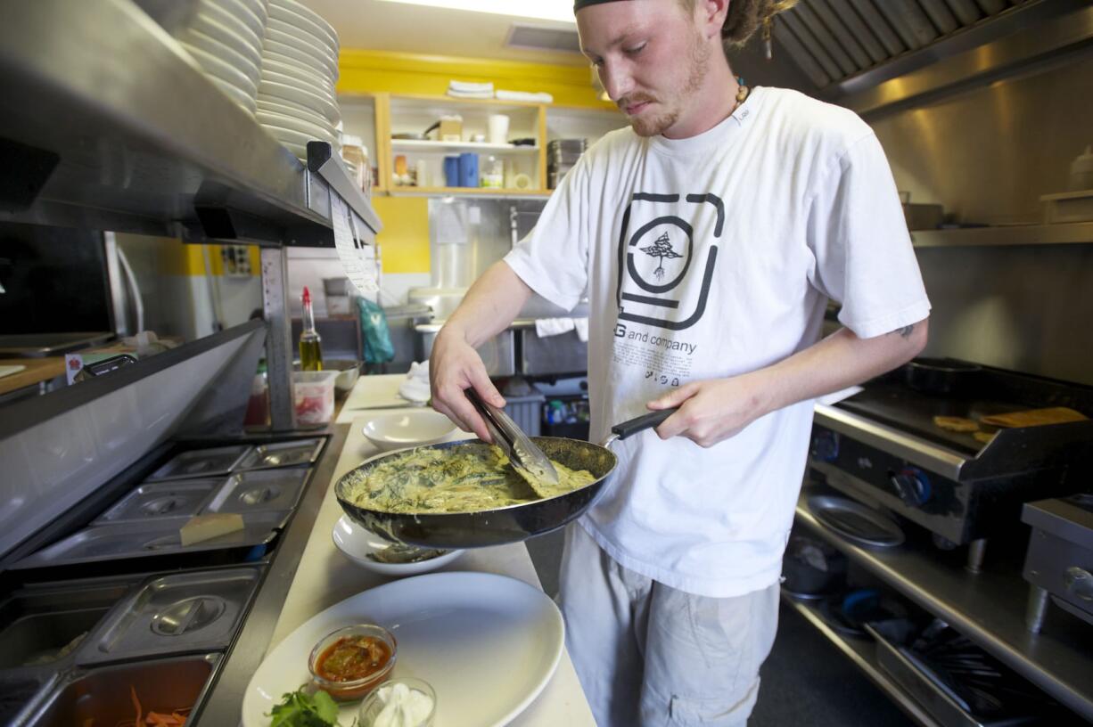 Photos by Steven Lane/The Columbian
Mint Tea chef Josh Simpson plates a kale and white bean ravioli with walnut basil pesto in a cream sauce during the lunch hour Thursday. Mint Tea is participating in a new health department program, Healthy Neighborhood Restaurants, that aims to get more healthful foods on menus.