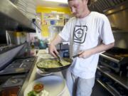 Photos by Steven Lane/The Columbian
Mint Tea chef Josh Simpson plates a kale and white bean ravioli with walnut basil pesto in a cream sauce during the lunch hour Thursday. Mint Tea is participating in a new health department program, Healthy Neighborhood Restaurants, that aims to get more healthful foods on menus.