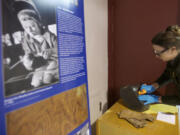 Meagan Huff, Fort Vancouver National Historic Site museum technician, puts the finishing touches on a display that includes welding gear used by Betty Jane Budd at Vancouver's Kaiser Shipyard.