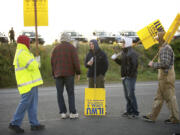 Vancouver police watch over ILWU Local 4 supporters holding signs outside the main gate to United Grain early Wednesday morning in Vancouver.