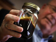 Williston, North Dakota Mayor E. Ward Koeser displays a jar containing Bakken crude oil, May 2, 2013.