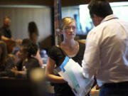 Cody Coss, 16, a Homelink student, listens to Ed Bush, an employment specialist with Goodwill, at a Youth Summer Job Fair in May at the Vancouver Community Library.