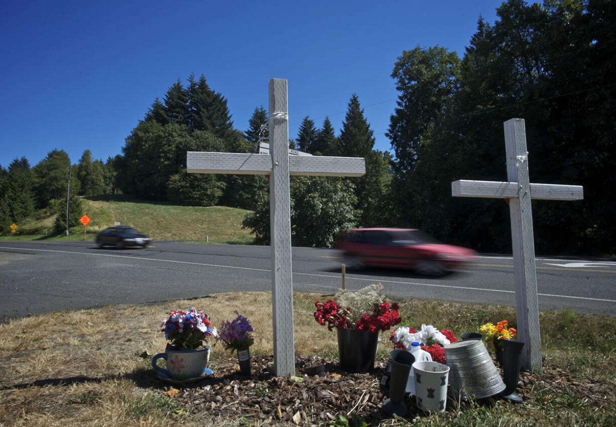 Traffic rolls past a memorial for Karey Brown and Steven Dodd on Northwest La Center Road near Northwest Eagle Crest Drive.