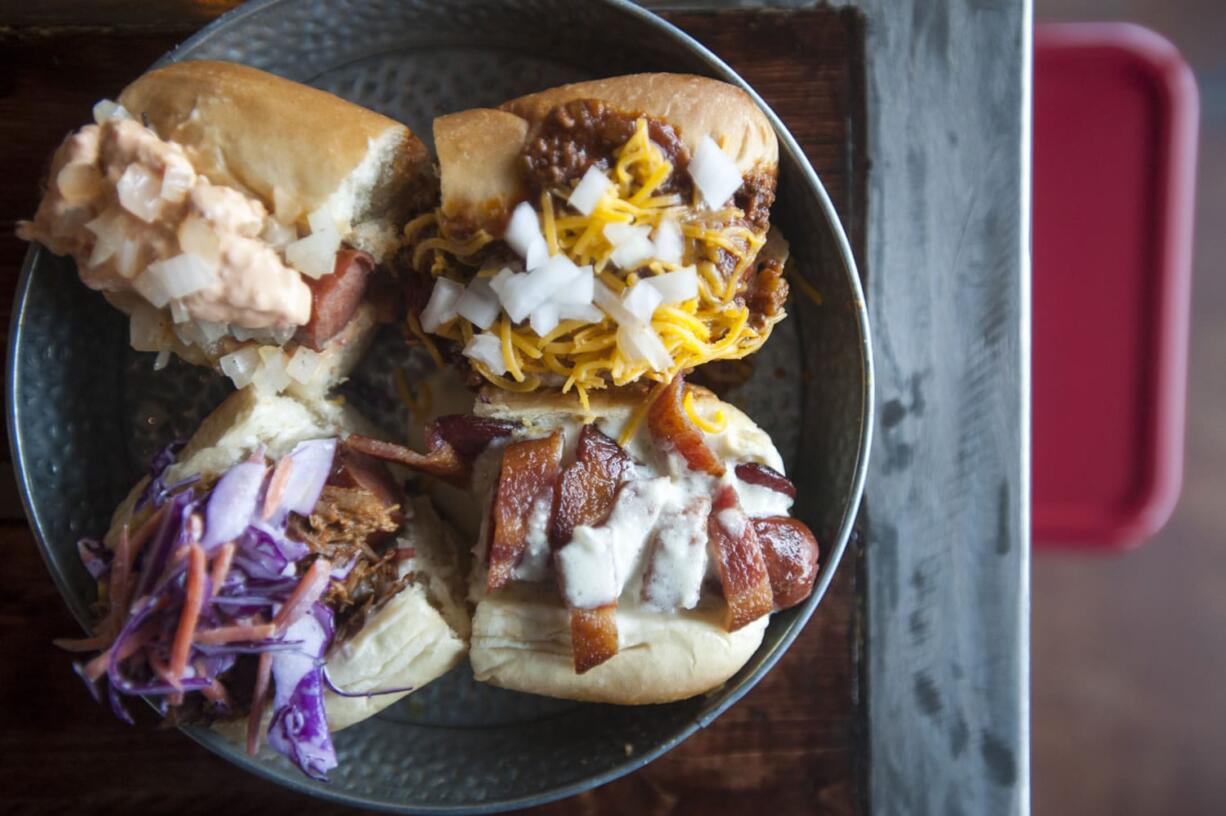 Natalie Behring/The Columbian The Pick of the Litter -- beef dogs topped with, clockwise from top left, pimento cheese, chili, bacon with Gorgonzola cheese sauce, and barbecue pork are served Dec. 4 at Mad Dogs Gourmet Hot Dogs in Vancouver.