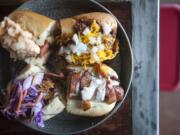 Natalie Behring/The Columbian The Pick of the Litter -- beef dogs topped with, clockwise from top left, pimento cheese, chili, bacon with Gorgonzola cheese sauce, and barbecue pork are served Dec. 4 at Mad Dogs Gourmet Hot Dogs in Vancouver.