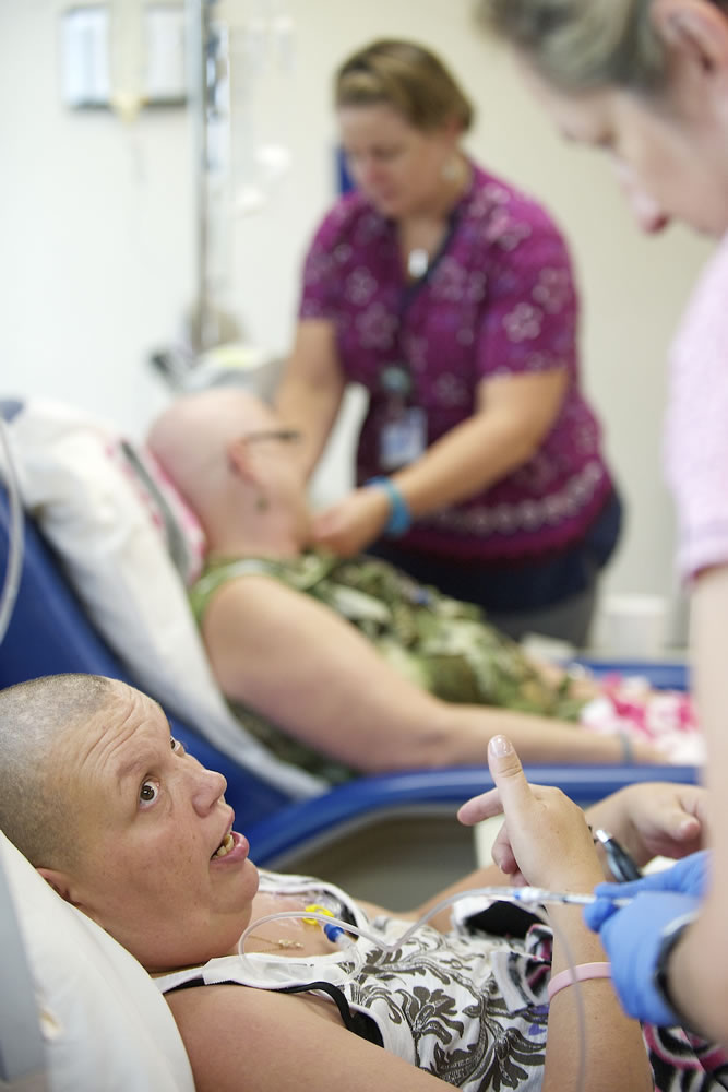 Crystal Alhilali, left, talks to a nurse administering her chemotherapy drug.