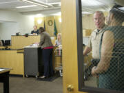 Clark County sheriff's custody officer Vaughn Gano calls an inmate from a secure area during a Superior Court session on Monday at the Clark County Courthouse.