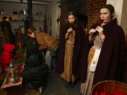 Megan Bruns, 16, center, and Megan Wilcox, 18, play Christmas carols on penny whistles at Fort Vancouver. Re-enactors could be found in every corner of the stockade as stories were spun and songs sung at the fort&#039;s annual holiday event.