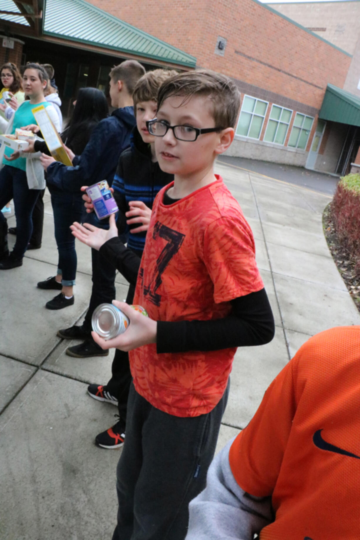 Battle Ground: Daybreak Middle School seventh-grader Colby Marsh helps move some of the in 3,851 pounds of food he and other Daybreak students collected for Battle Ground Public Schools&#039; annual holiday food drive, which brought in 23,928 pounds of food for the North County Food Bank.