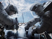 Sandra Bullock, left, and George Clooney play astronauts in peril in &quot;Gravity.&quot;