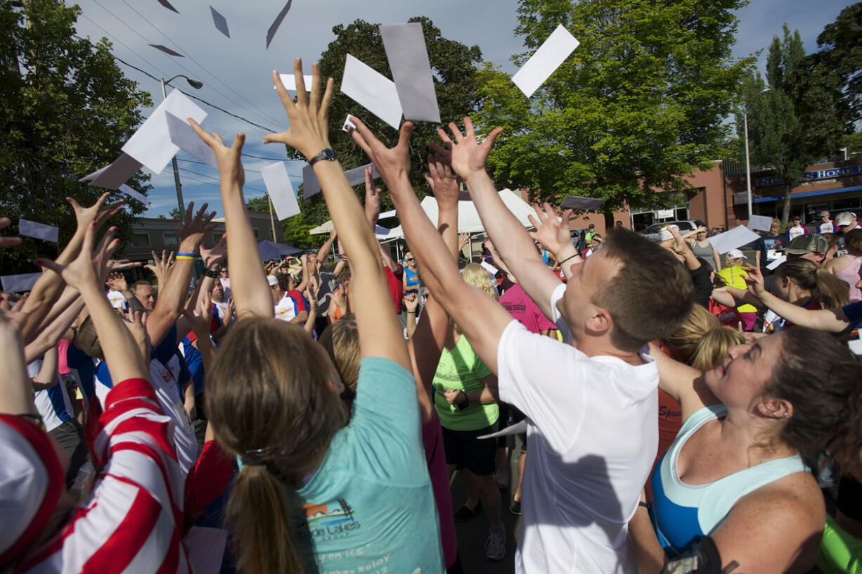 Runners reach for envelopes containing challenges and clues to complete the Summer Solstice Fun Run on Saturday in downtown Vancouver.