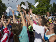 Runners reach for envelopes containing challenges and clues to complete the Summer Solstice Fun Run on Saturday in downtown Vancouver.