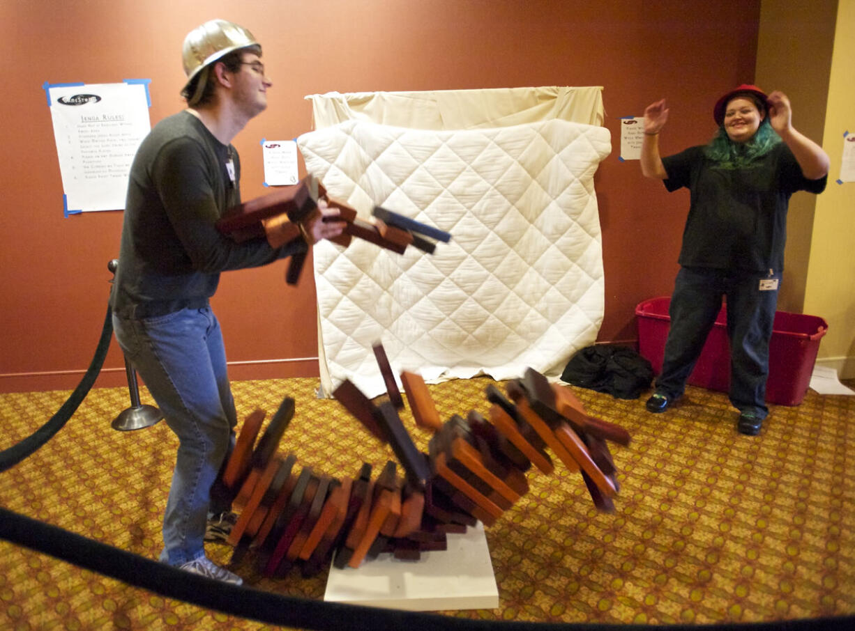 Brandon Suter, 25, of Eugene, Ore., watches the tower fall at the end of a game of giant Jenga with Keri Turner, 36, of Portland, in a hallway of the Hilton Vancouver Washington during Gamestorm.