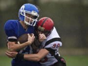 La Center's Taylor Dreyer is hit by Mount Baker's Hunter Gates in the first half of a 1A state quarterfinal game at District Stadium in Battle Ground on Saturday.