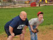 Ralph Heiser, left, demonstrates defensive positioning to Christopher Brothers during a Miracle League baseball practice. Heiser started as a volunteer coach for the Columbia River Miracle League.