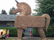 Robyn McCracken looks toward her granddaughter, Casey Lane McCracken, 3, on Friday while sitting near the 20-foot Trojan unicorn that her friend Frank James Mabry III  gave to her.