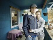 Harly and Courtney Forbes stand on the front porch where their tandem bicycle, which was locked, was stolen during the early morning hours Monday.