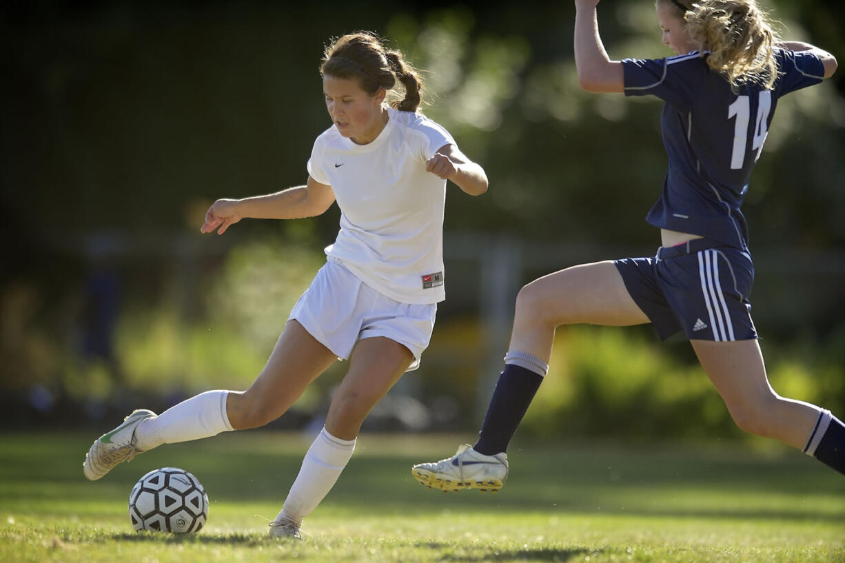 Easton Kawawaki, 6, left, of Columbia River High School takes a shot on goal in the second half against defender Michel Berry, 14, of Hockinson High School Tuesday in Vancouver.