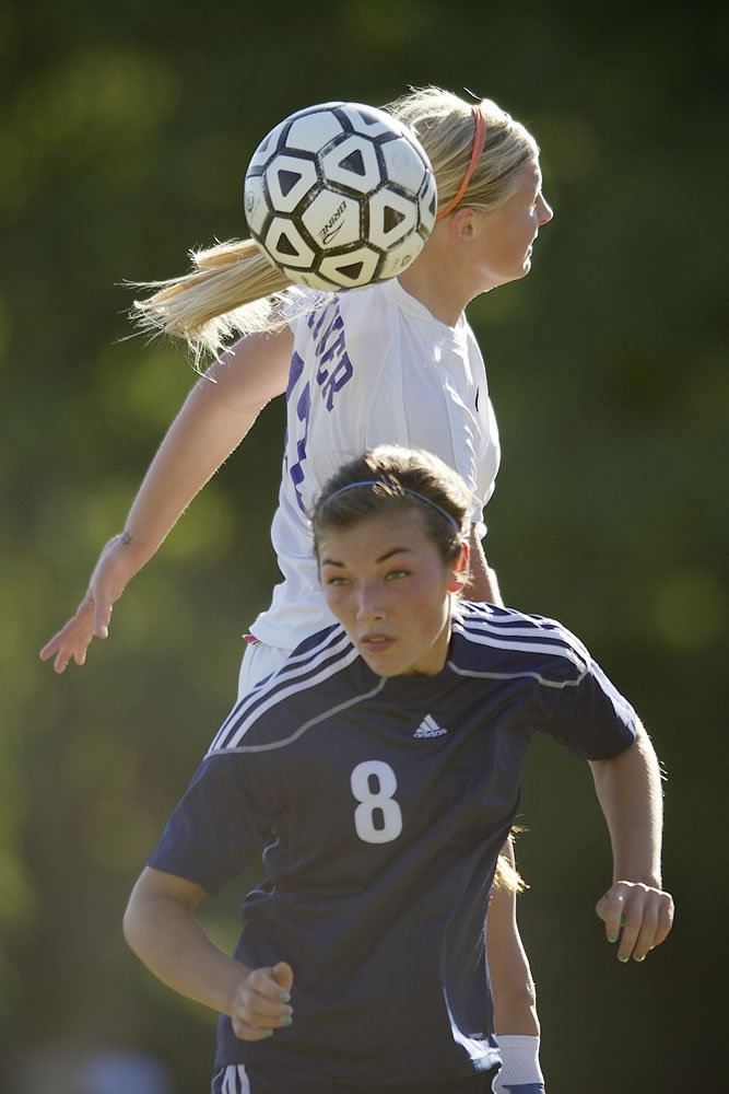 Maddie Reynolds of Columbia River High School misses a header on a corner kick against Maya Nicol, 8, of Hockinson during Wednesday's season opener.