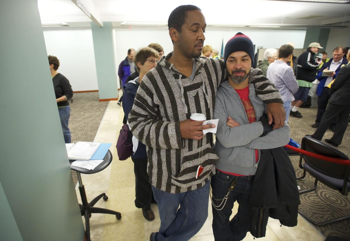 Jermonne Swendell, left, and his partner of 20-years Joe Apodaca, 46, both of Battle Ground, line up with other same-sex couples to apply for marriage licenses at Clark County Auditor's Office on Thursday.