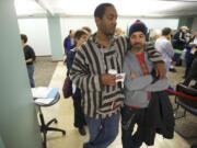 Jermonne Swendell, left, and his partner of 20-years Joe Apodaca, 46, both of Battle Ground, line up with other same-sex couples to apply for marriage licenses at Clark County Auditor's Office on Thursday.