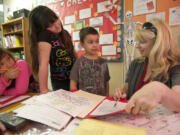 Crestline Elementary third-grade teacher Melody Autry-O'Dell helps students, from left, Kimi Ripoyla, Alise Tremble and Anthony Lazcano in their new classroom at Riverview Elementary on Thursday.