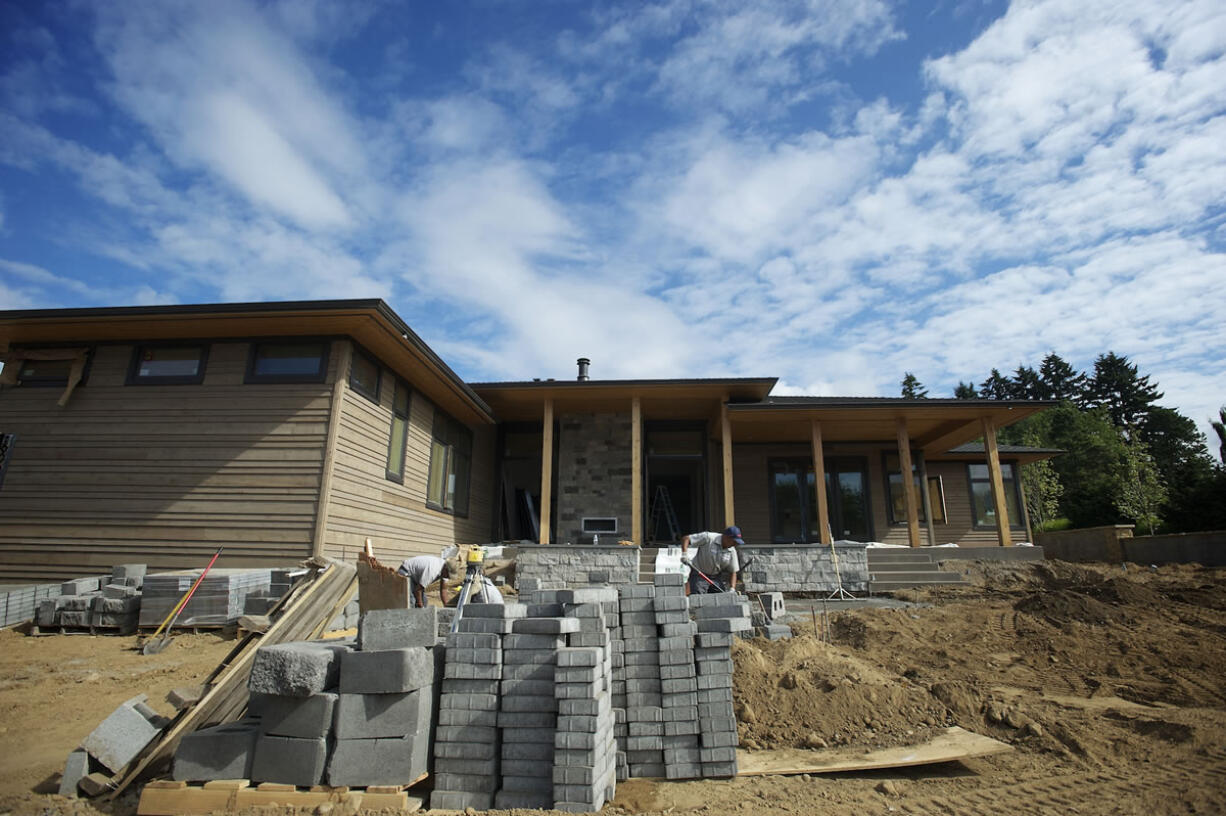 Work continues outside &quot;The Odyssey,&quot; one of four homes to be showcased starting Friday at the NW Natural Parade of Homes at Evergreen Pointe, a development near the Columbia River in Vancouver.