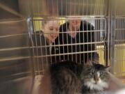 Alaina Stewart, left, and Brannon Stockton look into a cat cage at the Humane Society for Southwest Washington in Vancouver this month. The holidays are a common time to adopt a pet.