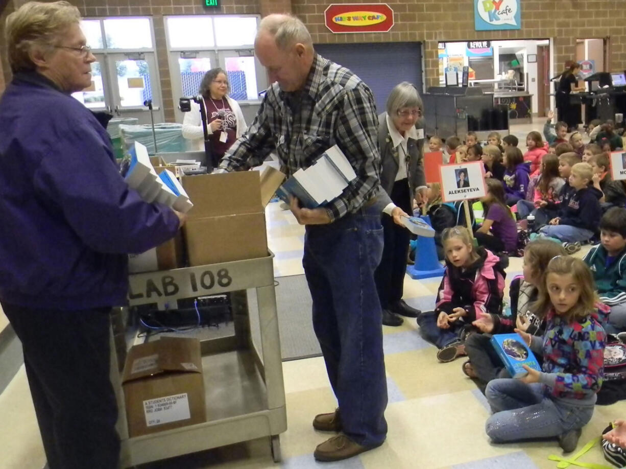 Battle Ground: Members of Battle Ground Elks Lodge No. 2589 Jean Boodey, from left, Ken Kanooth and Shirley Rooney distribute dictionaries Oct.