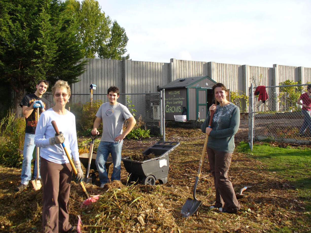 Hazel Dell: Ryan Evan, from left, WSU Master Gardener Bobbi Bellomy, Forrest Mock and Carrie Hanson-Muxlow spread bark chips in the Hazel Dell School and Community Garden.