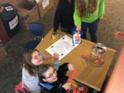 Camas: Grass Valley fifth-graders Megan Bauer, seated left, and Lily Thompson, seated right, accept donations from Hossana Abbay, top left, and Autumn Aho at a donation drive for the Humane Society for Southwest Washington.