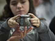 Heritage High School student Darlina Rose, 16, examines a 70-year-old creamer that contained a World War II-era telegram announcing the death of fighter pilot 2nd Lt.