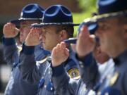 Washington State Patrol troopers salute during the national anthem.