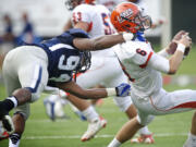 Rayshawn Wess, 94, of Skyview High School sacks quarterback Rhys Gervais, 6, of Lakes High School during the second half in a game at Kiggins Bowl on Friday.