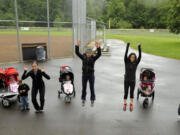 Personal trainer Kim Puyleart, second from right, leads participants in her Vancouver Mommy Fitness Playgroup through an exercise at Hockinson Meadows Park in Hockinson on Tuesday.