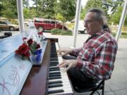 Dezy Walls, a musician and playwright from Carlton, Ore., performs &quot;Write Myself a Ltter&quot; on a painted Aerosonic Baldwin piano outside Vancouver City Hall.