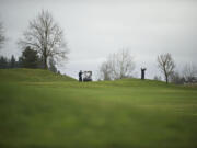 Golfers hit from the fairway on the 18th hole at the Tri-Mountain Golf Course.