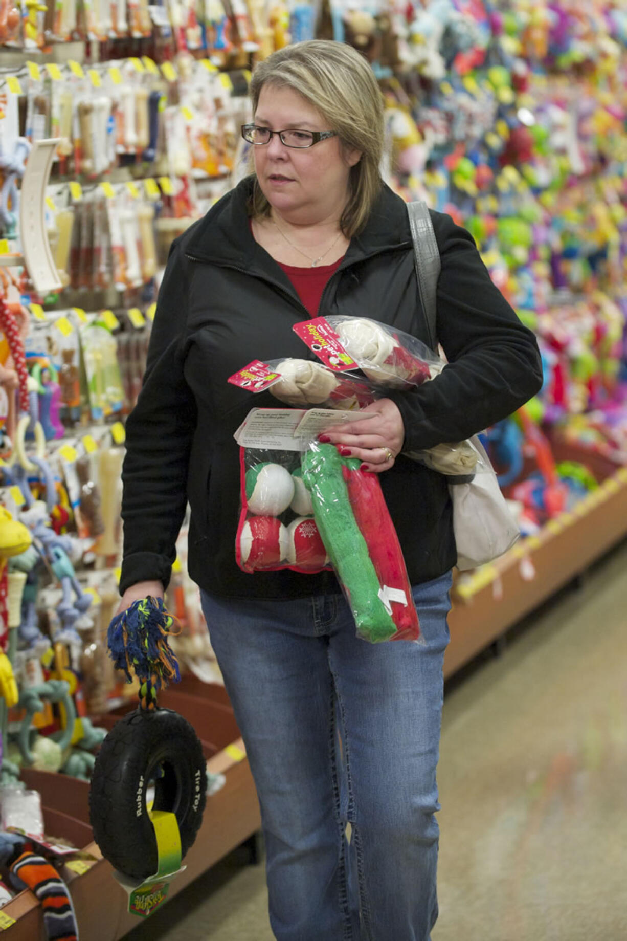 Kendall Aichele shops for toys for her daughters' 9-month-old Labrador-shepherd mixes at the Hazel Dell PetSmart Saturday. The dogs aren't the only ones getting gifts from the pet store.