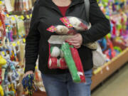 Kendall Aichele shops for toys for her daughters' 9-month-old Labrador-shepherd mixes at the Hazel Dell PetSmart Saturday. The dogs aren't the only ones getting gifts from the pet store.