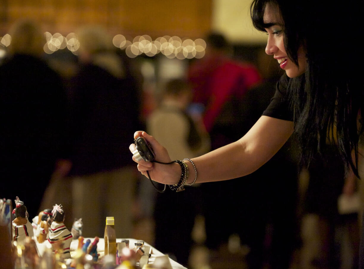 Gretta Rogers of Vancouver focuses on one of 659 nativity scenes at the 12th annual Festival of Nativities Sunday in east Vancouver.