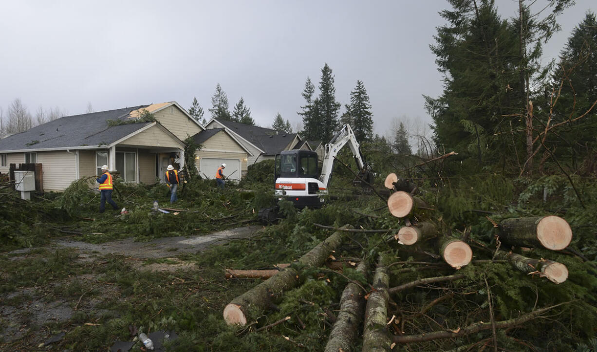 A crew from Battle Ground Public Works clears the aftermath of a tornado that tore through the city at about 11:15 a.m. Thursday, uprooting trees and damaging homes and power lines.